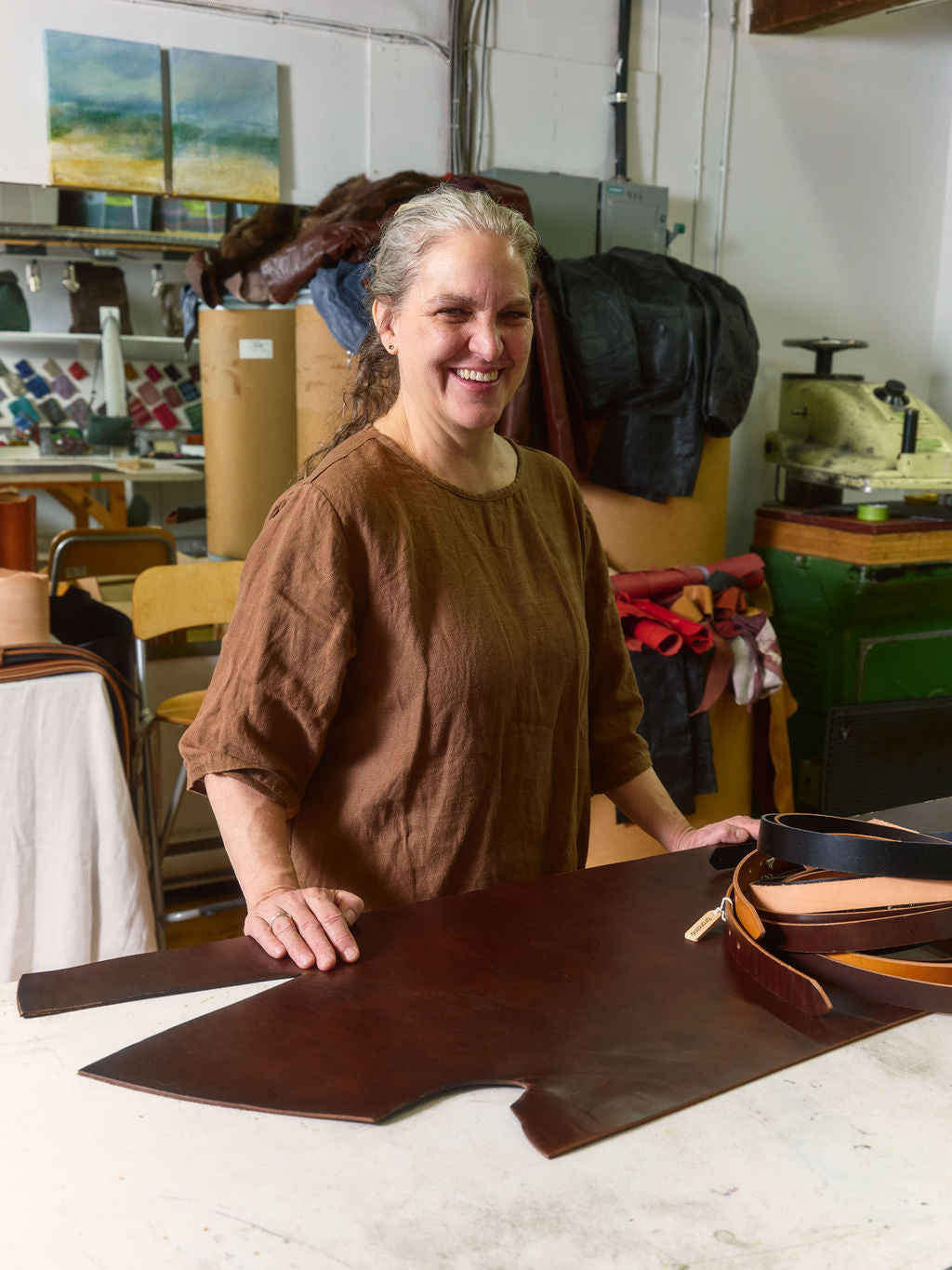 Denise, founder of Bronsino, handcrafting luxury leather goods in her East Vancouver artist studio.